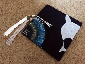 Calvin's graduation cap included his two tassels, one for each degree, and was painted with a silhouette of SpaceShipTwo and his iris (in the style of the Virgin Galactic logo).